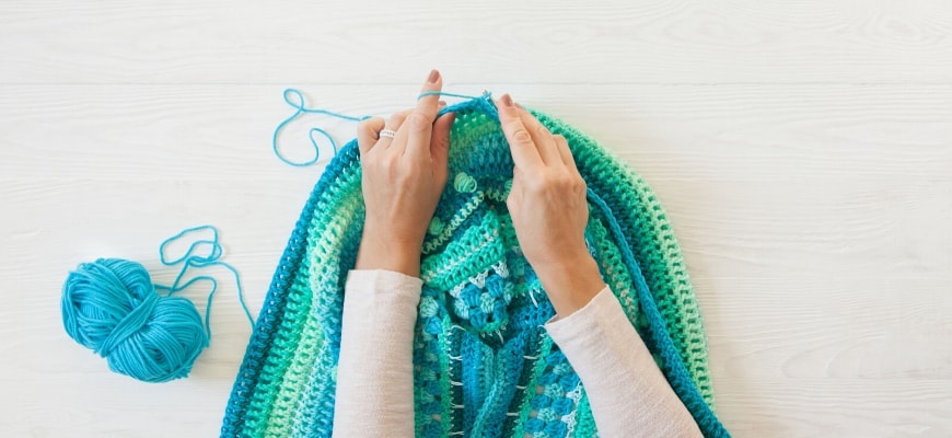 Cropped view of woman's hand doing a crochet.