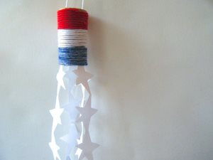 Wrap red, white, and blue yarn around a toilet paper roll to form patriotic stripes.