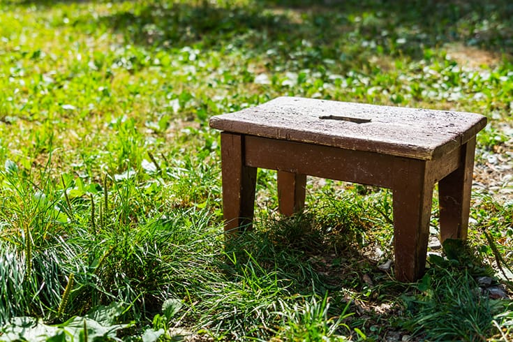 Wooden step stool on a meadow in the sunshine summer