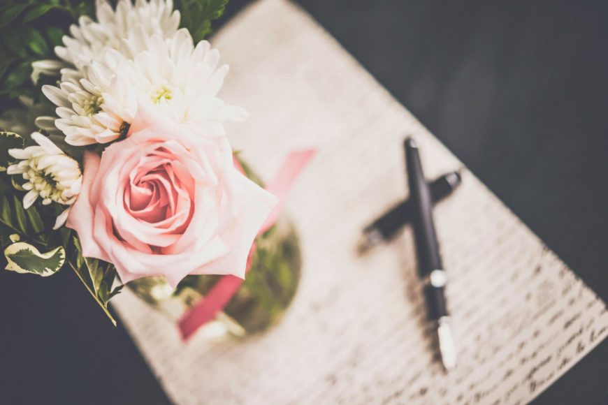 Flowers on the vase, pen and paper with writings