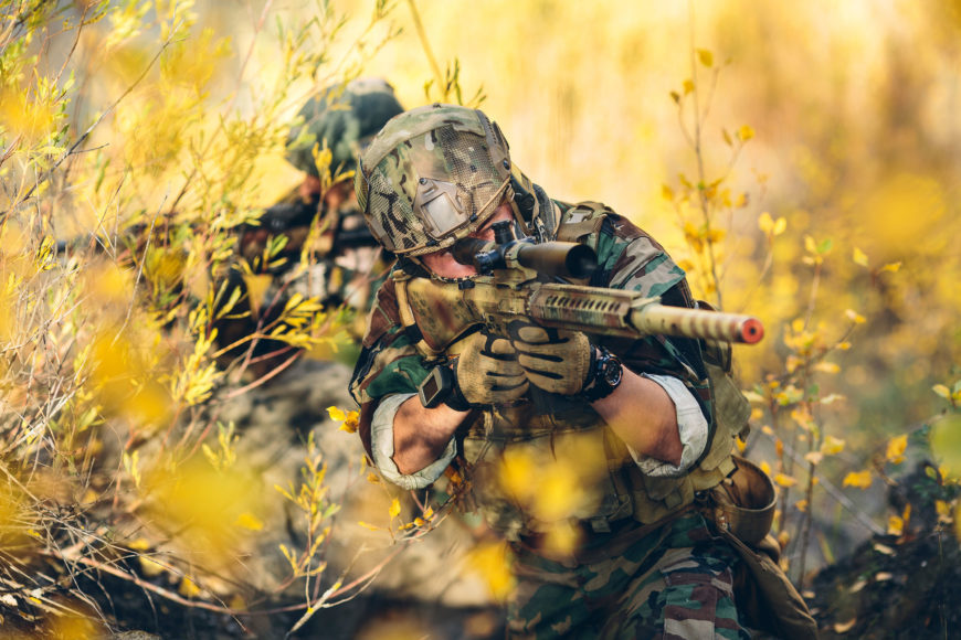 Two soldiers on the field holding rifles