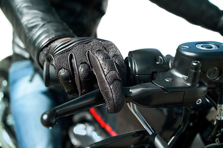 Close up image of a motorcycle rider with hand gloves