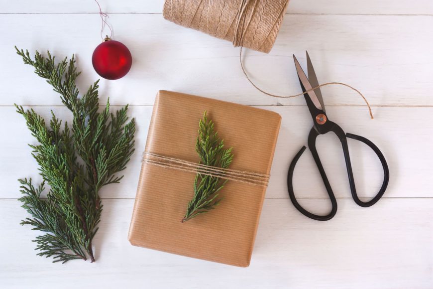 Scissor, string, pine tree leaves and brown note tide with a pine tree leaves.