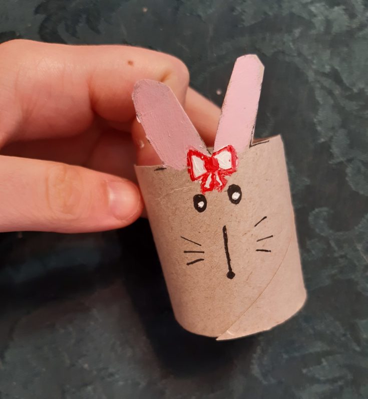 Cardboard tube with painted bunny ears and drawn eyes,nose and whiskers.