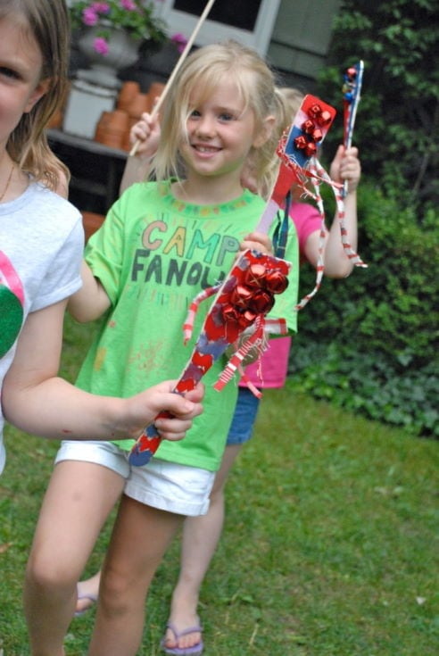 kids holding wooden cooking utensils into their own works of art