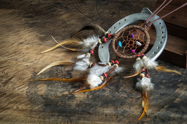 Leather dream catcher and horseshoe on wooden floor