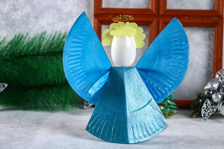 The process of creating your own Christmas angel from a disposable cardboard plate, a plastic spoon and paper. Christmas decor. Handmade, hobby, DIY