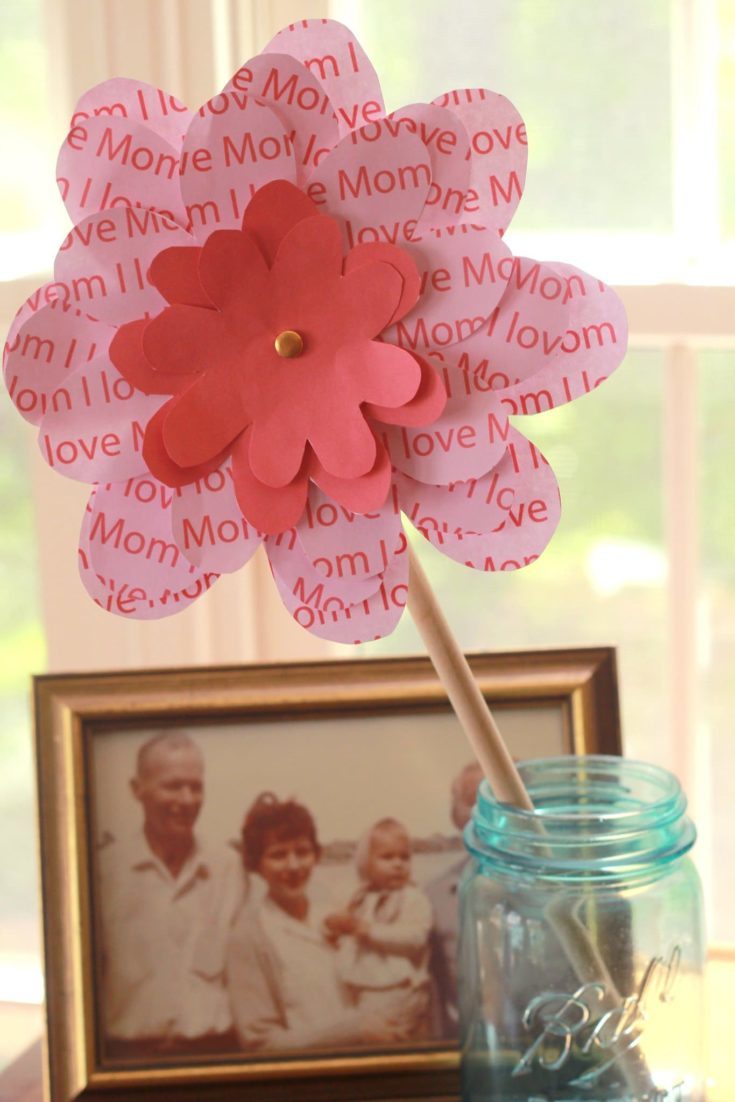 A floral pinwheel for mom put on a mason jar and a picture frame at background.