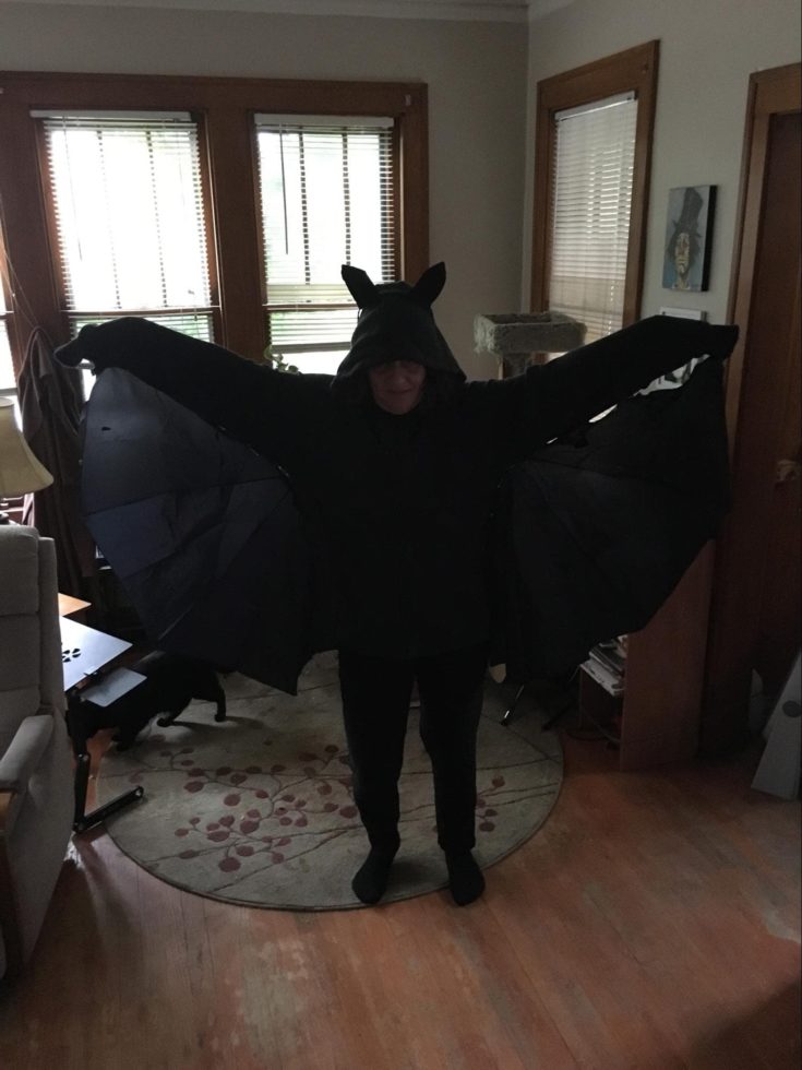 a woman wearing all black bat halloween costume