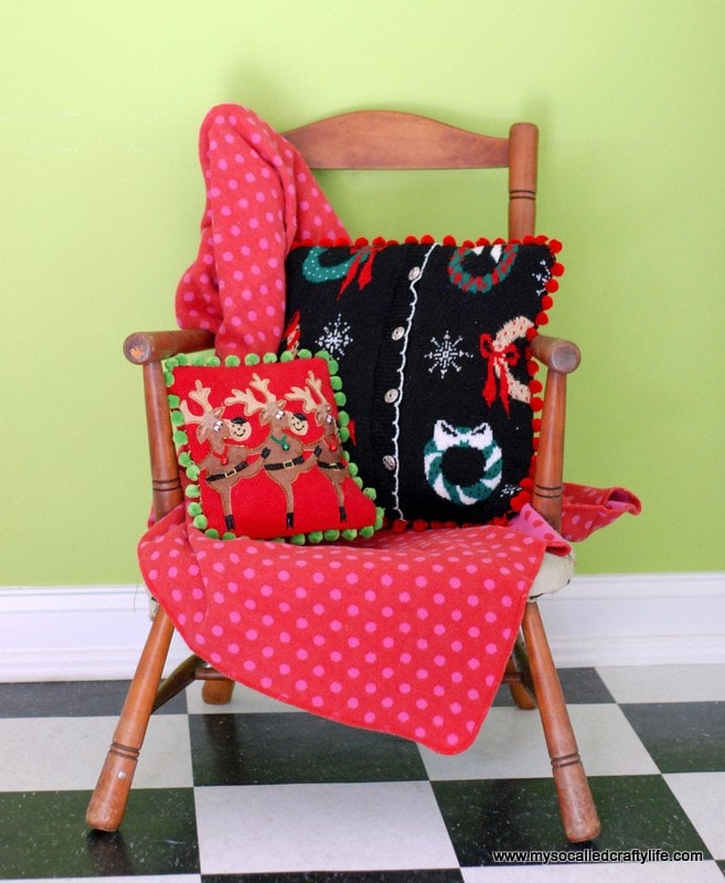 Christmas sweater with black and red Christmas themed pillow