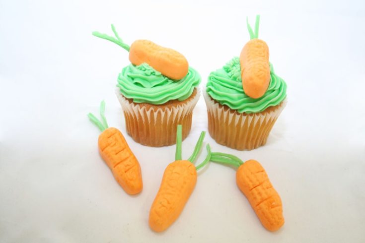 Circus Peanut Carrot Toppers on top of cup cake.