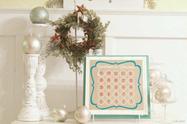 Desktop advent calendar with Christmas garland and two candle holders on top of a dresser