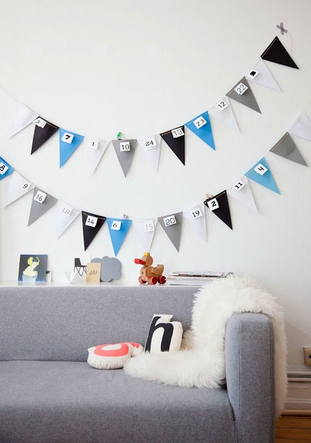 DIY colored banner on a white wall at the back of gray sofa