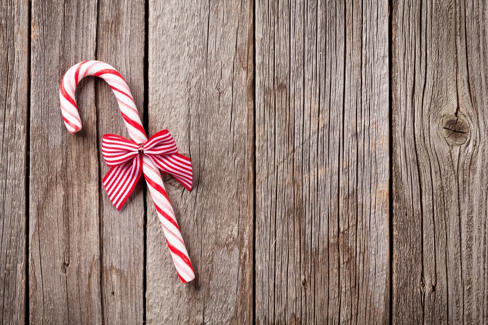 Christmas candy cane on wooden table. Top view with copy space