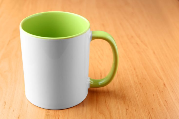 White with green mug for branding on wooden table