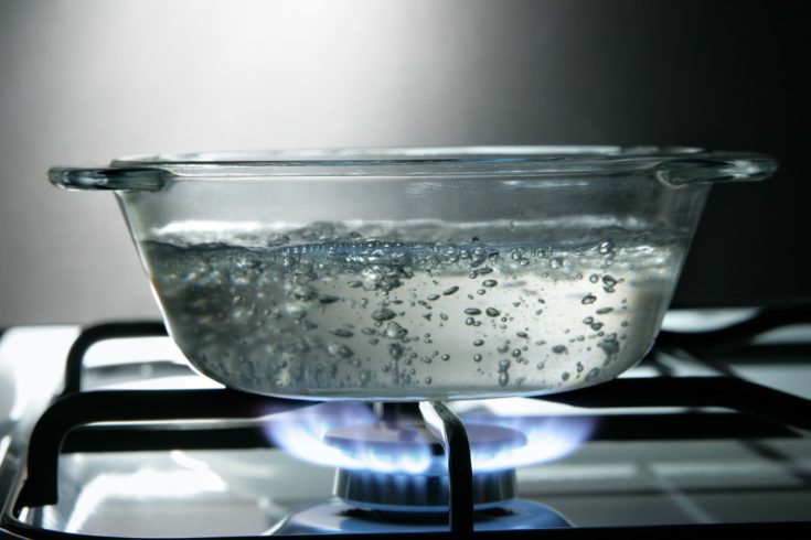 Glass saucepan on the gas stove close-up