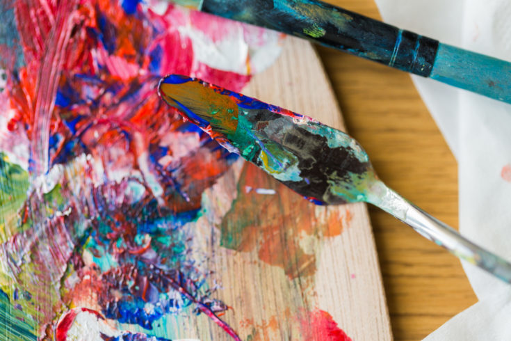 fine art, creativity and artistic tools concept - close up of palette knife or painting spatula and paintbrush from top