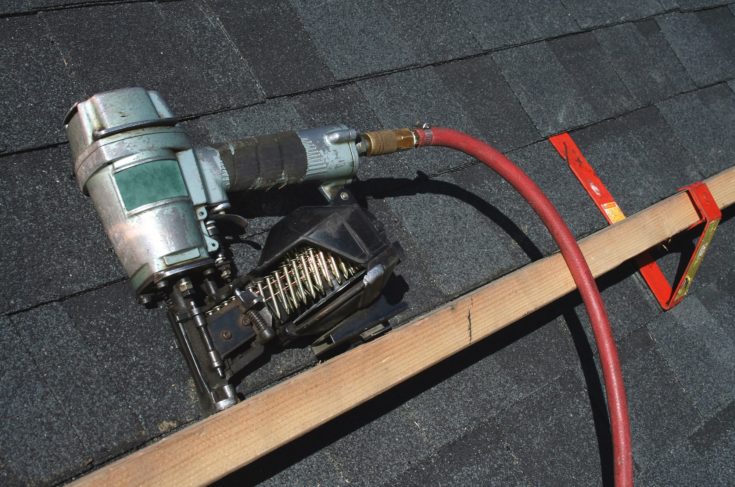 A Pneumatic roofing nail gun with air hose. Tank is out of sight