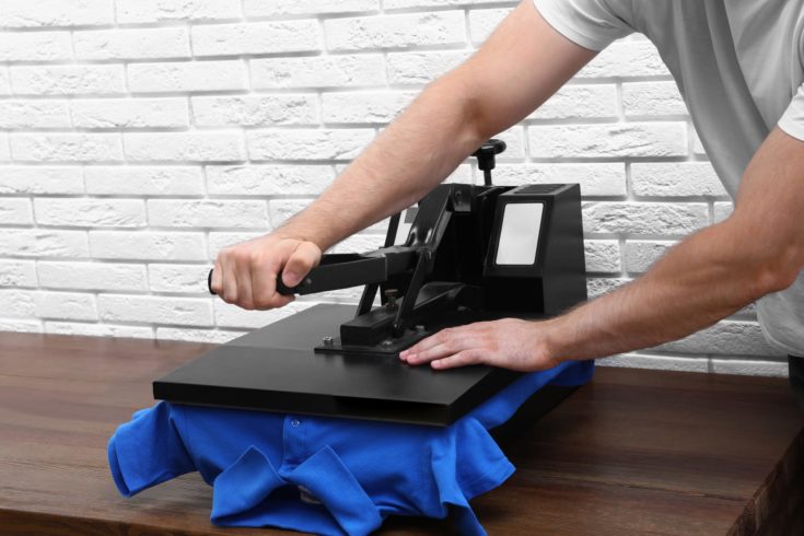 Man use heat press machine for t-shirt printing