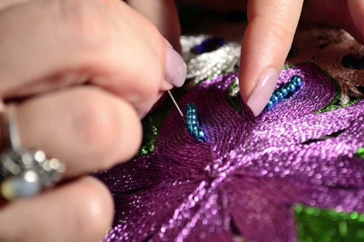 Woman embroiders with gold thread