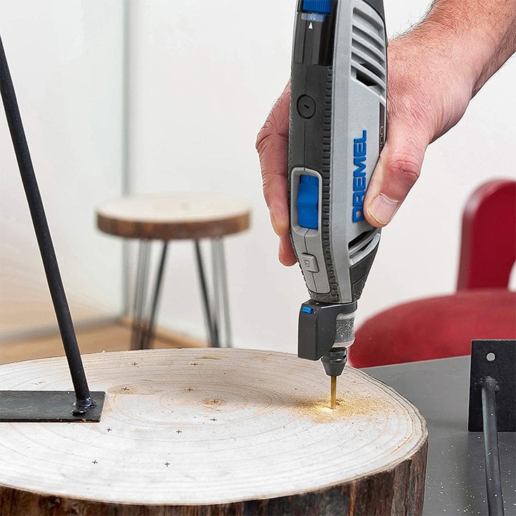 man's hand using Dremel drill bit