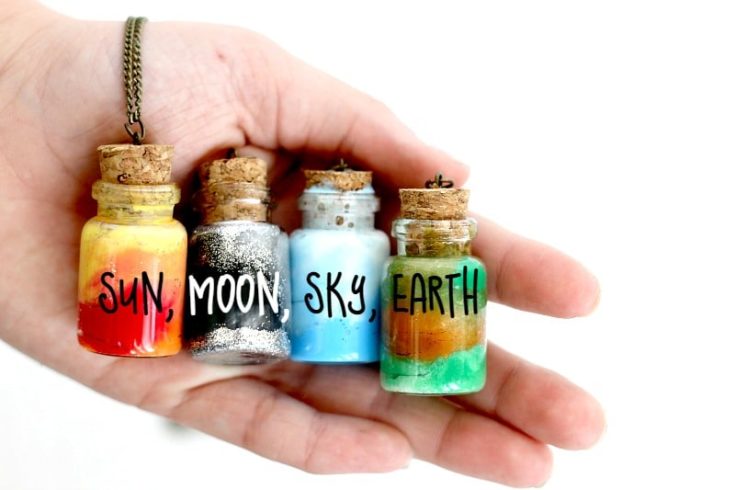 a hand holding four Element Jar Friendship Necklaces