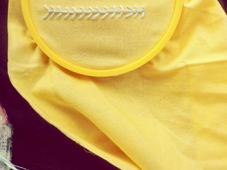 fly stitch embroidery example in a yellow cloth
