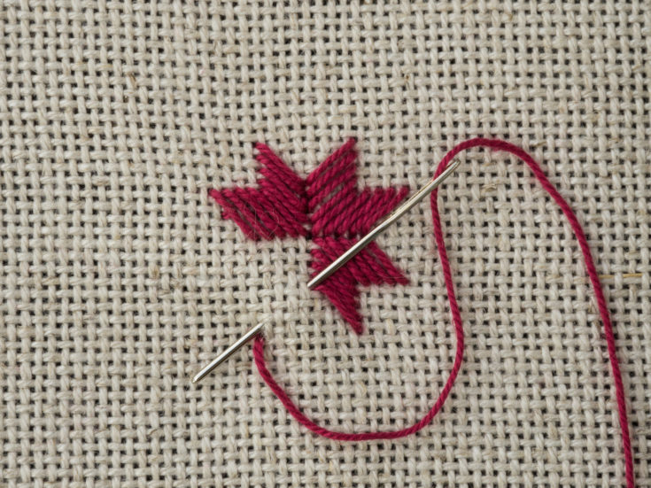 Fragment of embroidery on the canvas with a needle