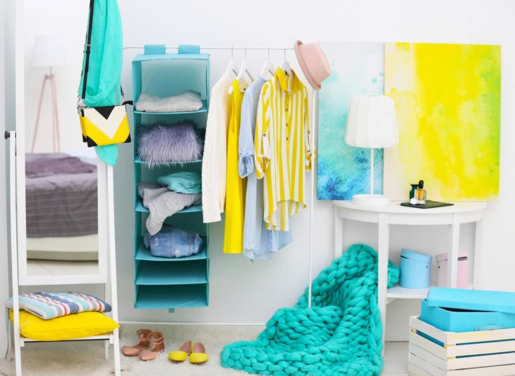 Fashionable clothes hanging on rack at modern dressing room