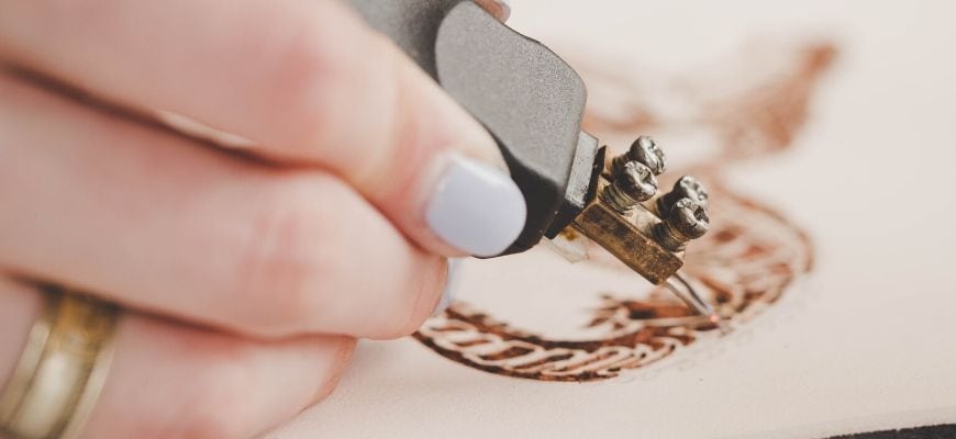 Woman's hand making design on the wood