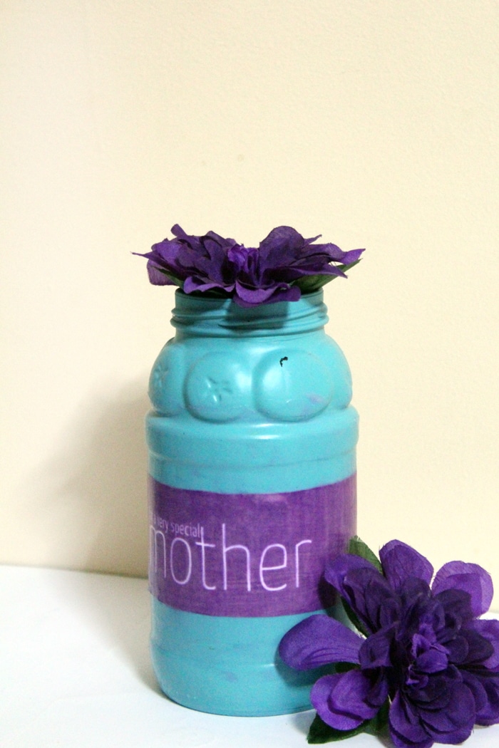 Upcycled mason jar vase with purple flowers.