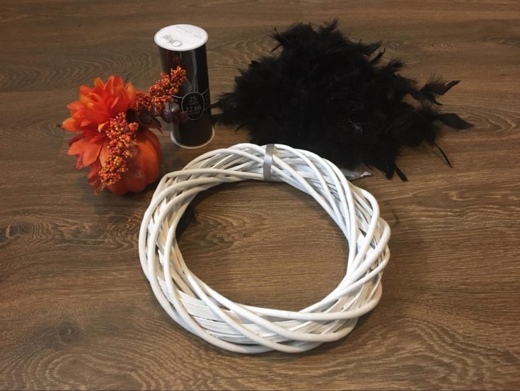 wreath + pumpkin decoration + black feather boa + black fabric