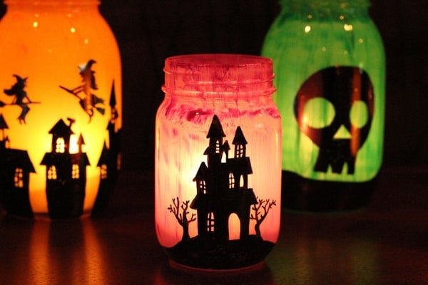 Jar luminaries painted inside with colors and designs for halloween.