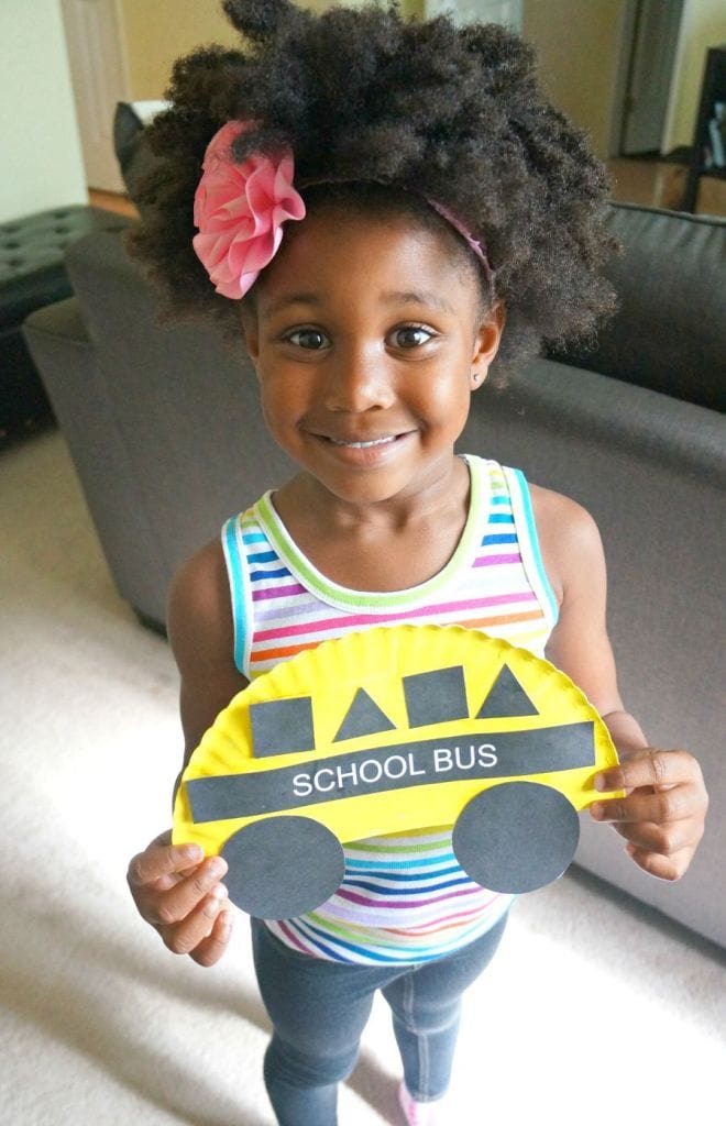 Pattern Practice - Young girl holding a school bus craft using a paper plate.