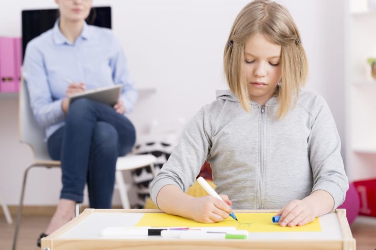 Pediatric occupational therapist observing a child patient with autism