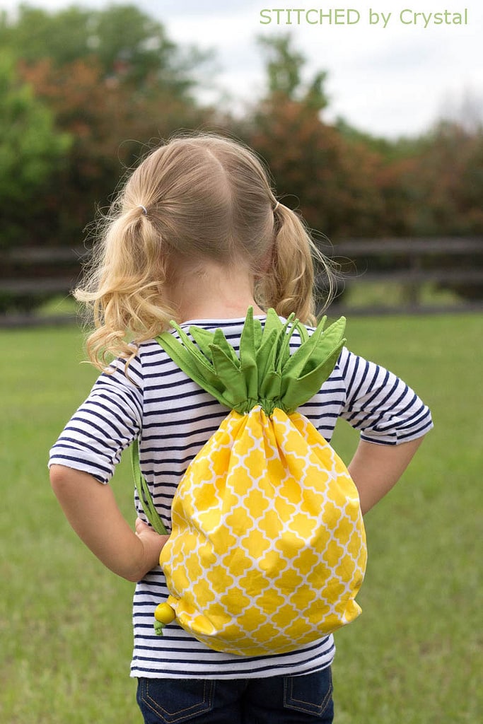 a little girl with Pineapple Drawstring Backpack