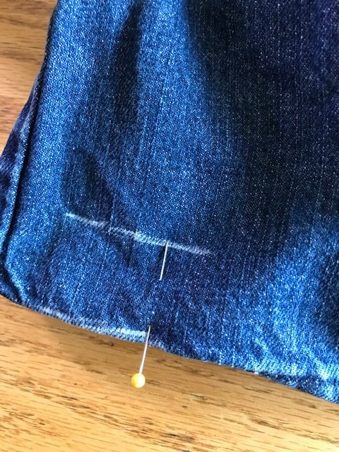 Pinning the jeans with one pin and a mark on it