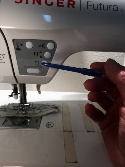 Pointing the reverse button of the sewing machine