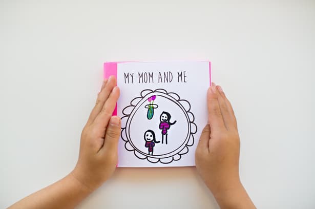 Woman's hand holding a Printable Mother’s Day Book.