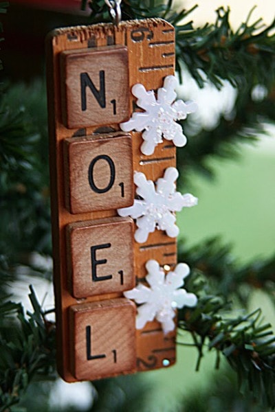 NOEL spelled with scrabble pieces pasted on a ruler with snowflakes ornament