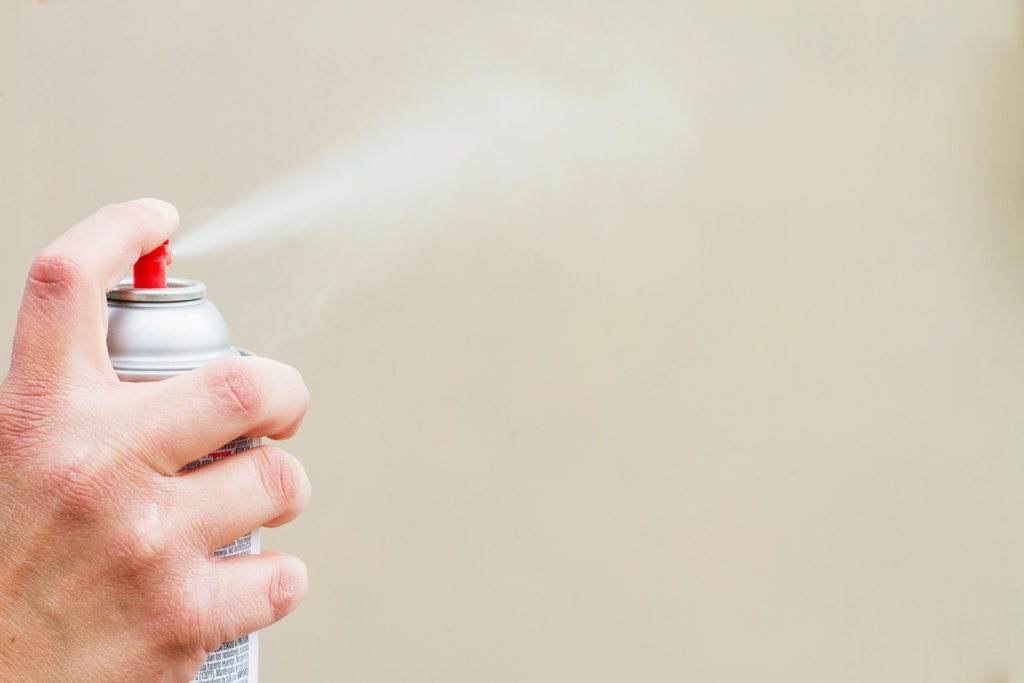 a person spray painting with blank background.