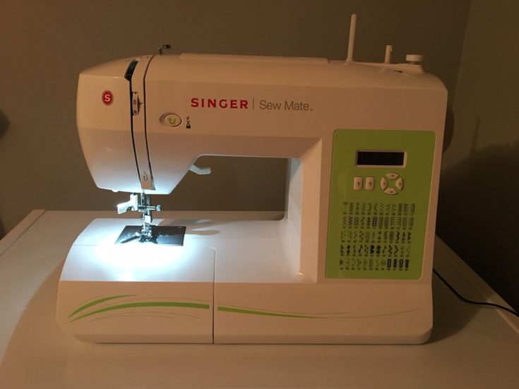 a white Singer Sew Mate sewing machine on the top of the table