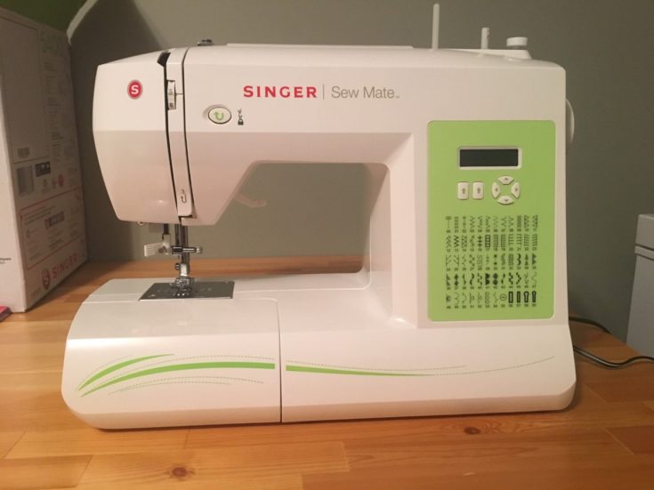 a white Singer Sew Mate sewing machine on the top of the table