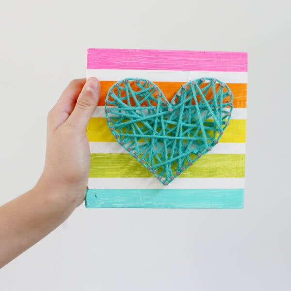 a hand holding String Art Heart Kids Craft