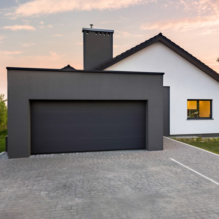 Stylish house with garage and cobblestone driveway, outdoors