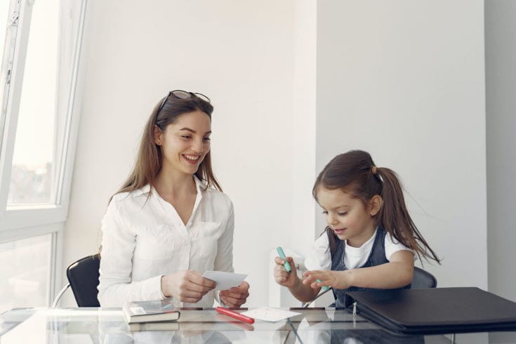 happy mother and daughter writing inside the office