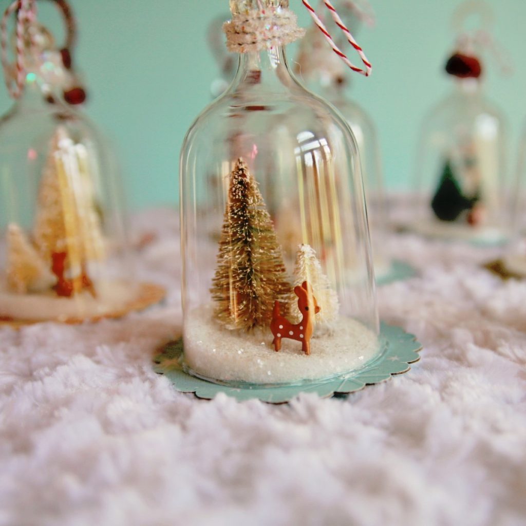 Clear glass bell ornament with Christmas tree and reindeer inside