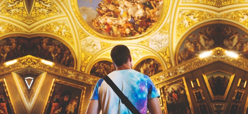 A closed shot of man looking on a paintings on wall and ceiling.