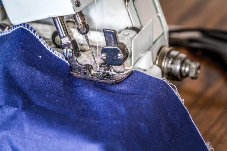 Work at the sewing machine, stitching fabric edge at overlock