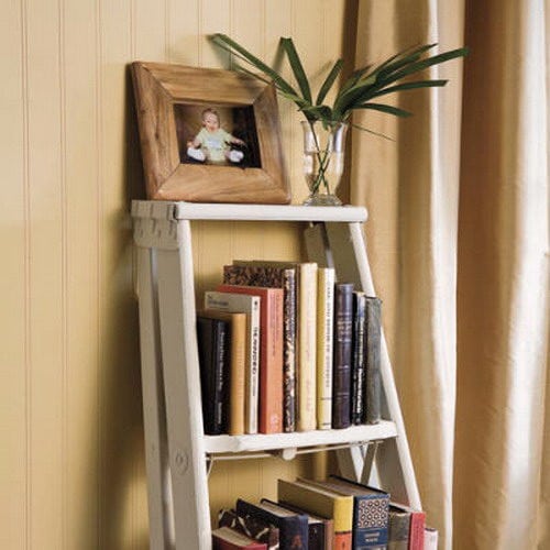 white ladder resting on brown wall with wooden frame on top